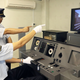 Two men in train station outfits operate the simulator.
